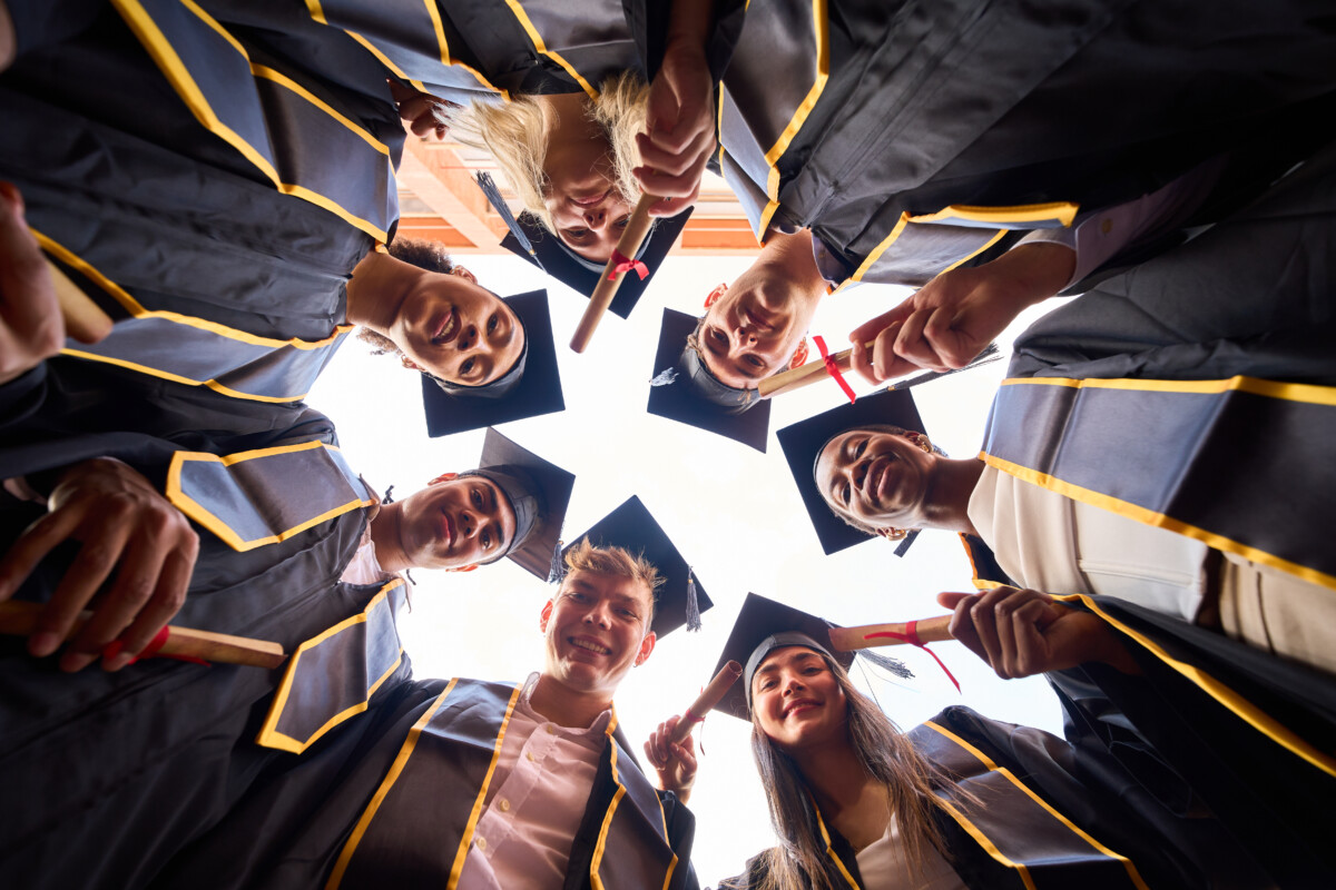 International students celebrating graduation day with diplomas